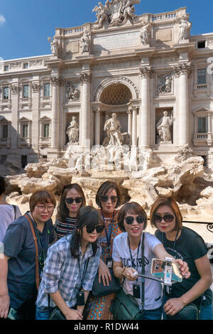 Tourists taking a group selfie photograph in front of the Trevi Fountain,  Rome, Italy. Stock Photo