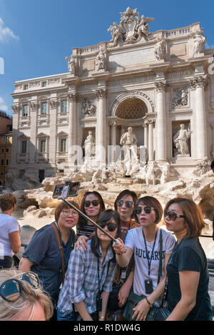 Tourists taking a group selfie photograph in front of the Trevi Fountain,  Rome, Italy. Stock Photo