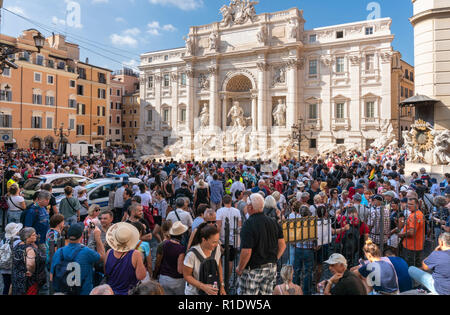 Hordes of tourists visiting the Trevi Fountain, one of the most popular tourist attractions in  Rome, Italy.