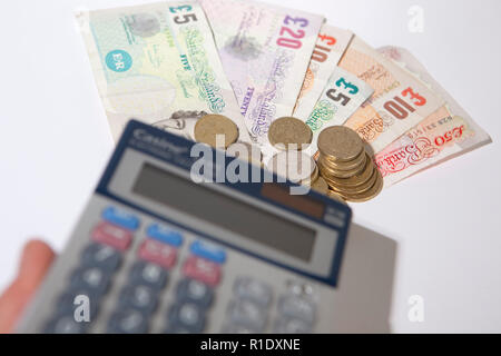 Illustrative image of various denomination sterling pound notes and coins. Stock Photo