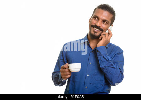 Young happy Indian businessman talking on mobile phone and holdi Stock Photo