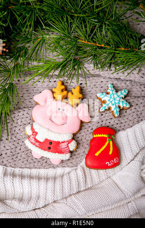 Gingerbread piggy and snowflake on the background with fir branches, flat lay, top view. Holiday sweets. New Year's and Christmas theme. Festive mood. Christmas Card Stock Photo