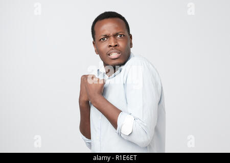 Emotional scared african male looking with frightened expression as sees something awful. He is nervous demonstrating phobia. Stock Photo