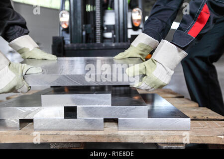 Workers taking aluminium billet at CNC machine shop Stock Photo