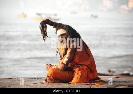 Varanasi, Hindus, Holy Ganges River. A sadhu or holy man in the early morning sunlight by the Holy Ganges River at Varanasi. Stock Photo