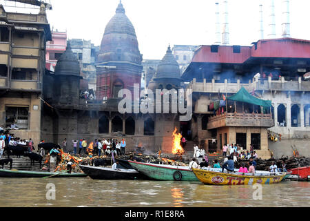 Varanasi, Hindus, Holy Ganges River. Mourners at the crematorium ghat at Varanasi as bodies burn. Stock Photo