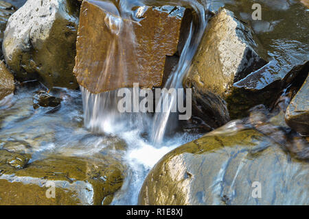 One of the thousands of waterfalls of Putorana plateau. The rapid flow of water among the rocks. Stock Photo