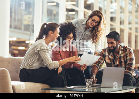 Multiethnic group of business people working together in office. businessman sitting with female colleagues discussing work. Stock Photo