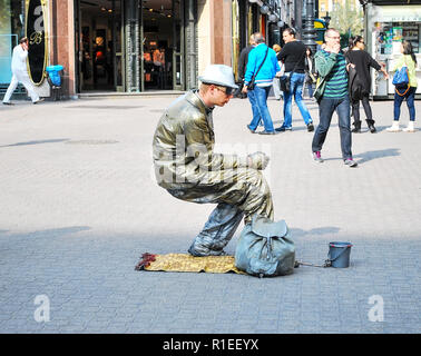 Dresden, Germany. May 13, 2014: Street artist on the street in Dresden depicts a frozen statue. Dresden - one of the most visited cities in Germany. I Stock Photo