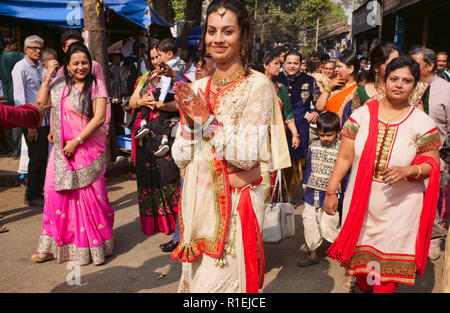 A Gujarati wedding party in Matunga, a suburb of Mumbai, India, spills out into the street, the bride up front with traditionally henna-painted hands Stock Photo