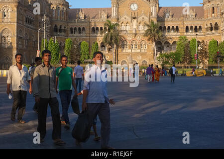 Passers-by in Mumbai, India, in front of Chhatrapati Shivaji Maharaj Terminus, the city's busiest railway station and a UNESCO heritage site Stock Photo