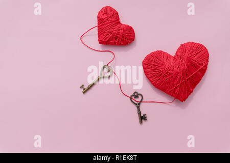 Valentines Day concept.key and red hearts isolated on pink background.Skeleton key with Love and red rope hearts. Mothers Day and love concept background with copy space Stock Photo