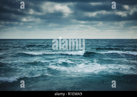Water waves on cloudy sky background. Stock Photo
