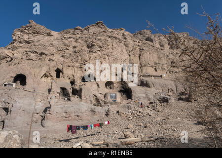 Troglodyte Village With Laundry Drying In The Foreground Near Bamyan, Bamyan Province, Afghanistan Stock Photo