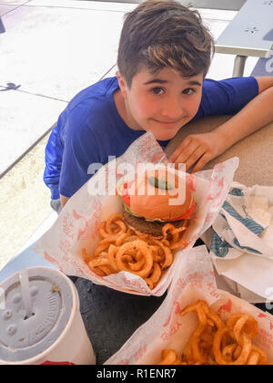 APRIL 25, 2018 - ORLANDO, FLORIDA: TWELVE YEAR OLD BOY WITH FOOD AT THE SIMPSONS IN UNIVERSAL STUDIOS. Stock Photo