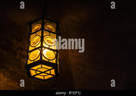 Wrought iron lantern hanging in a medieval castle vault, with copy space. Stock Photo