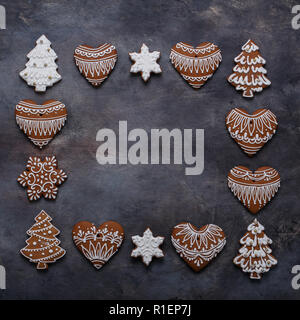 Gingerbread cookies frame on dark background. Snowflake, star, tree, top view copy space Stock Photo