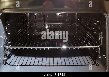A view of the cross section of an open empty household stove from the inside, the view from the direction of the open door. Stock Photo
