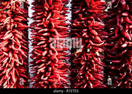 Close up of bright red chili peppers strung together, called ristras, common to Southwestern and Mexican cuisine Stock Photo
