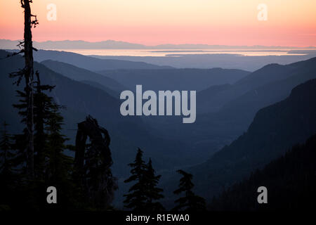 Sunset, sun set, over mountains. Sunset mountains panoramic. Colorful and scenic sunset over the Cascade Mountains. Looking towards Vancouver Island. Stock Photo