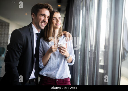 Friends colleagues dressed in formal wear drinking coffee and laughing having working break Stock Photo