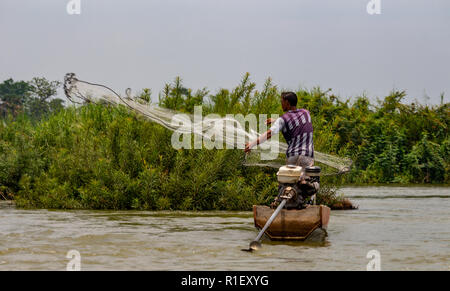 Nakasong, Laos - April 22, 2018: Fisherman throwing a fishing net in the water of the Mekong river in the 4000 islands zone near Cambodian border Stock Photo