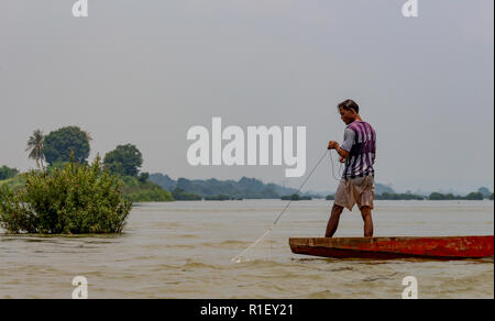 Nakasong, Laos - April 22, 2018: Fisherman holding a fishing net in the water of the Mekong river in the 4000 islands zone near Cambodian border Stock Photo