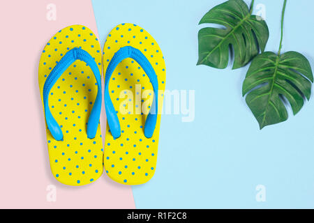 Yellow sandals with shell on blue color background, Summer holidays accessories . flat lay photo Stock Photo