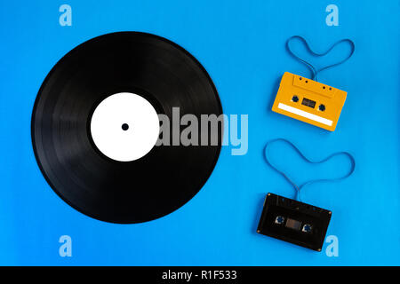 old vinyl records and audio cassette tape with film shape heart  on blue background Stock Photo