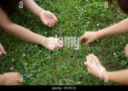 Woman's Hand picking up pieces of paper in garden, hand holding piece of garbage Stock Photo