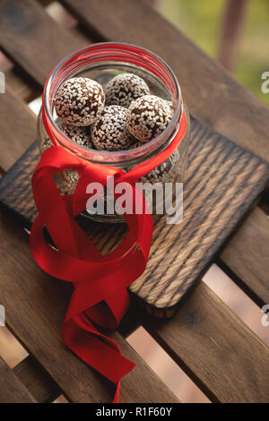 Healthy homemade energy balls with cranberries, nuts, dates and rolled oats on parchment, vertical. Stock Photo
