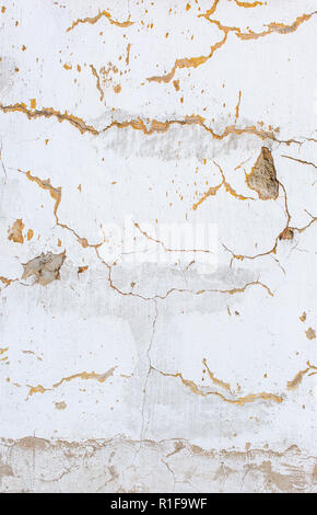 White scratched plaster wall background. Old wall with holes in plaster. Rough cracked stucco surface texture. Vertical photo Stock Photo