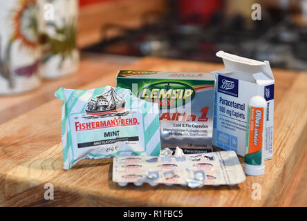 Variety of cold and flu medicines remedies bought from local chemist including Fishermans Friend , Lemsip all in one Olbus oil and paracetamol tablets Stock Photo