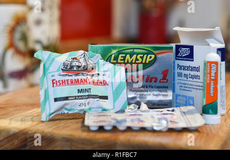 Variety of cold and flu medicines remedies bought from local chemist including Fishermans Friend , Lemsip all in one Olbus oil and paracetamol tablets Stock Photo