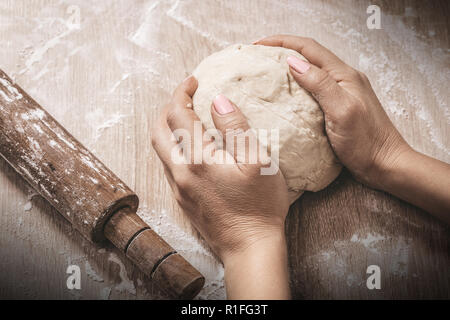 woman chef kneads the dough, hands, close-up Stock Photo
