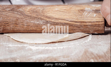 male cook rolls out dough with rolling pin Stock Photo