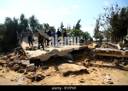 Khan Yunis, Gaza, Palestine. 12th Nov, 2018. Palestinians stand on the remains of a building that was destroyed by Israeli air strike in Khan Yunis.The israeli air force carried out air strike in the Southern Gaza strip area of Khan Younis on the night of 11 Nov causing damages to the building and human casualties. Credit: Ahmad Hasaballah/SOPA Images/ZUMA Wire/Alamy Live News Stock Photo