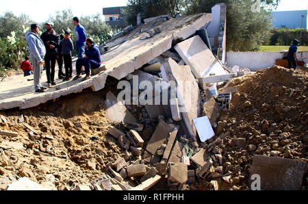 Khan Yunis, Gaza, Palestine. 12th Nov, 2018. Palestinians stand on the remains of a building that was destroyed by Israeli air strike in Khan Yunis.The israeli air force carried out air strike in the Southern Gaza strip area of Khan Younis on the night of 11 Nov causing damages to the building and human casualties. Credit: Ahmad Hasaballah/SOPA Images/ZUMA Wire/Alamy Live News Stock Photo