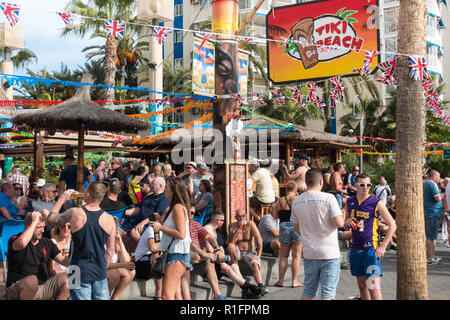 Benidorm, Costa Blanca, Spain 12th November 2018. The Tiki Beach Bar on Benidorm Levante Beach, a favourite hangout for British holidaymakers is still open despite recent reports that it was shutting down due to complaints about unruly behaviour. Staff were seen outside taking drinks off customers on the promenade and pouring them into plastic glasses. Boozy Brits have been blamed for anti-social behaviour at the popular beach front music bar. Credit: Mick Flynn/Alamy Live News Stock Photo