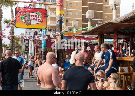 Benidorm, Costa Blanca, Spain 12th November 2018. The Tiki Beach Bar on Benidorm Levante Beach, a favourite hangout for British holidaymakers is still open despite recent reports that it was shutting down due to complaints about unruly behaviour. Staff were seen outside taking drinks off customers on the promenade and pouring them into plastic glasses. Boozy Brits have been blamed for anti-social behaviour at the popular beach front music bar. Credit: Mick Flynn/Alamy Live News Stock Photo