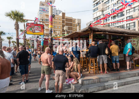 Benidorm, Costa Blanca, Spain 12th November 2018. The Tiki Beach Bar on Benidorm Levante Beach, a favourite hangout for British holidaymakers is still open despite recent reports that it was shutting down due to complaints about unruly behaviour. Staff were seen outside taking drinks off customers on the promenade and pouring them into plastic glasses. Boozy Brits have been blamed for anti-social behaviour at the popular beach front music bar. Credit: Mick Flynn/Alamy Live News Stock Photo