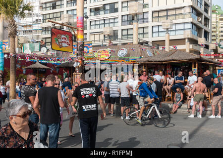 Benidorm, Costa Blanca, Spain 12th November 2018. The Tiki Beach Bar on Benidorm Levante Beach, a favourite hangout for British holidaymakers is still open despite recent reports that it was shutting down due to complaints about unruly behaviour. Staff were seen outside taking drinks off customers on the promenade and pouring them into plastic glasses. Boozy Brits have been blamed for anti-social behaviour at the popular beach front music bar. Credit: Mick Flynn/Alamy Live News Stock Photo