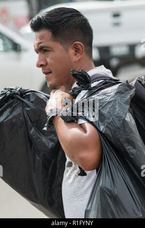 Irapuato, Guanajuato, Mexico. 12th Nov 2018. A Honduran refugee with the Central American migrant caravan walks with his belongings in black trash bags as he continues his journey northwest toward the U.S. border November 12, 2018 in Irapuato, Guanajuato, Mexico. The caravan has been on the road for a month is half way along their journey to Tijuana. Credit: Planetpix/Alamy Live News Stock Photo