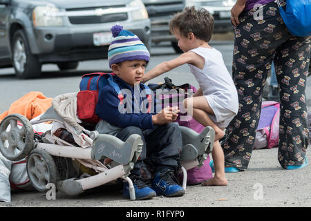 Irapuato, Guanajuato, Mexico. 12th Nov 2018. Young Honduran refugee children with the Central American migrant caravan wait alongside a busy road as they try to get a ride northwest toward the U.S. border November 12, 2018 in Irapuato, Guanajuato, Mexico. The caravan has been on the road for a month is half way along their journey to Tijuana. Credit: Planetpix/Alamy Live News Stock Photo