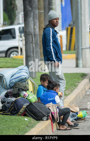 Irapuato, Guanajuato, Mexico. 12th Nov 2018. Young Honduran refugees with the Central American migrant caravan wait with their father on a busy road as they try to get a ride northwest toward the U.S. border November 12, 2018 in Irapuato, Guanajuato, Mexico. The caravan has been on the road for a month is half way along their journey to Tijuana. Credit: Planetpix/Alamy Live News Stock Photo