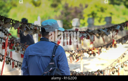 WUHAN/ HUBEI CHINA - OCT 03, 2018:  The man look at the keys and lock area. This keys is symbol of love and friendship and eternity. Stock Photo