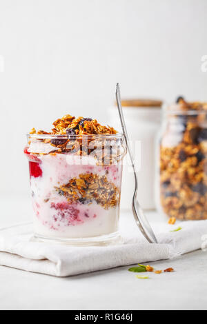Baked granola, jam and yogurt healthy breakfast parfait in glass. Healthy detox food concept. Stock Photo