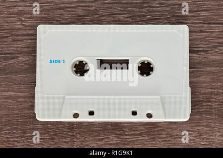 Vintage white audio cassette tape on brown wooden background. Side 1 Stock Photo
