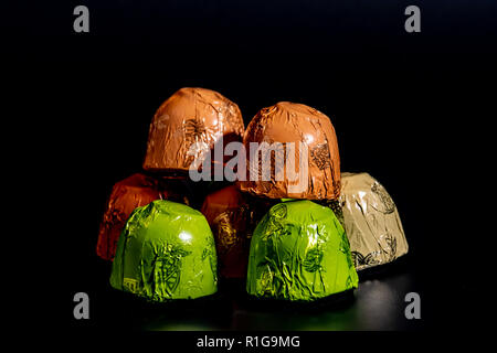 Chocolates in foil wrapper on black background 2018 Stock Photo