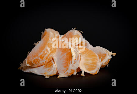 Half peeled mandarin on a black background close-up 2018 Stock Photo